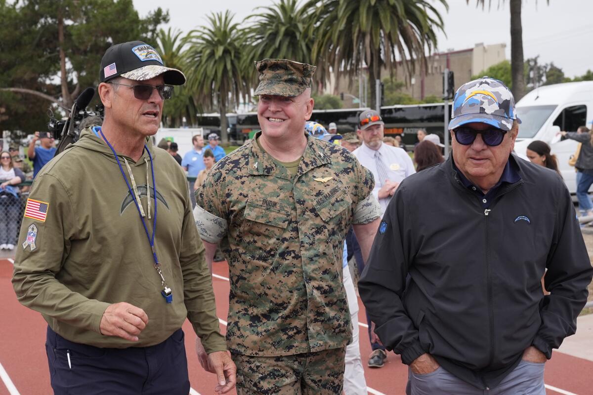 Chargers coach Jim Harbaugh (left) and owner Dean Spanos flank  Marine Colonel Charles Dudik.