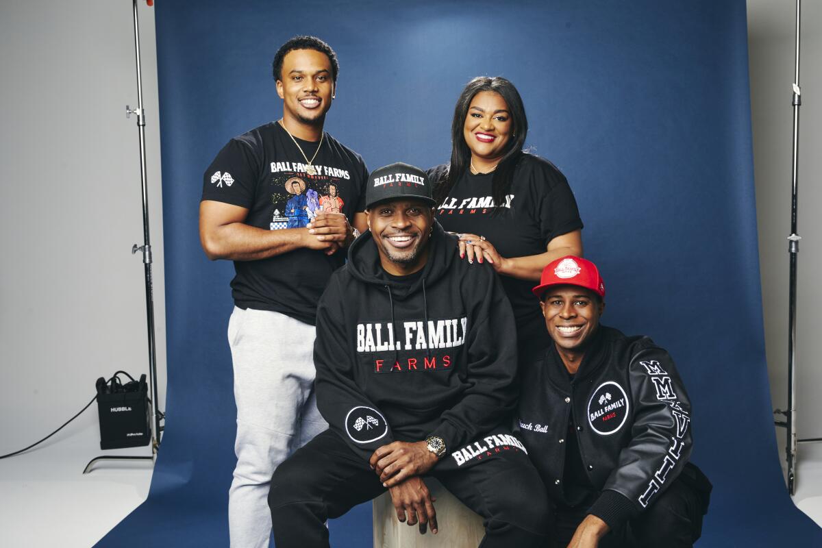 Four people wearing Ball Fall Farms merchandise posing for a photo