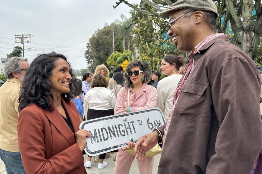 Los Angeles city councilmember Nithya Raman, left, talks with AT Center Board President Korey Wyatt (he/they), after the removal of anti-gay signs the first put up in the 1990s to discourage men from cruising in the Silver Lake neighborhood.