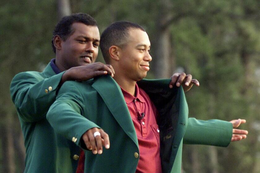 Tiger Woods, right, receives his Masters green jacket from last year's champion Vijay Singh, of Fiji, after winning the 2001 Masters at the Augusta National Golf Club in Augusta, Ga., Sunday, April 8, 2001. Woods captured this second Masters title, defeating David Duval by two stokes. (AP Photo/Doug Mills) Original Filename: MASTERS_AUH202.jpg