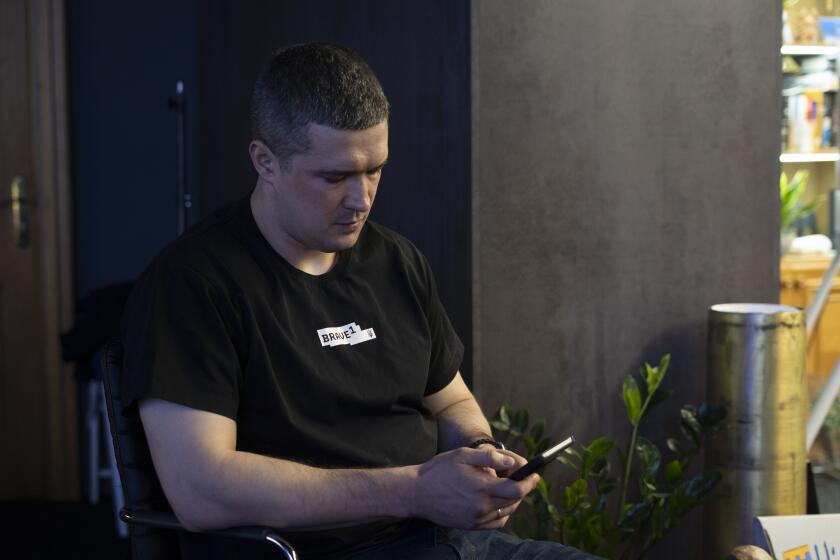 Ukraine’s Deputy Prime Minister of Innovations and Technology Mykhailo Fedorov looks at his phone after an interview with The Associated Press in Kyiv, Ukraine, Monday, Aug. 19, 2024. (AP Photo/Hanna Arhirova)