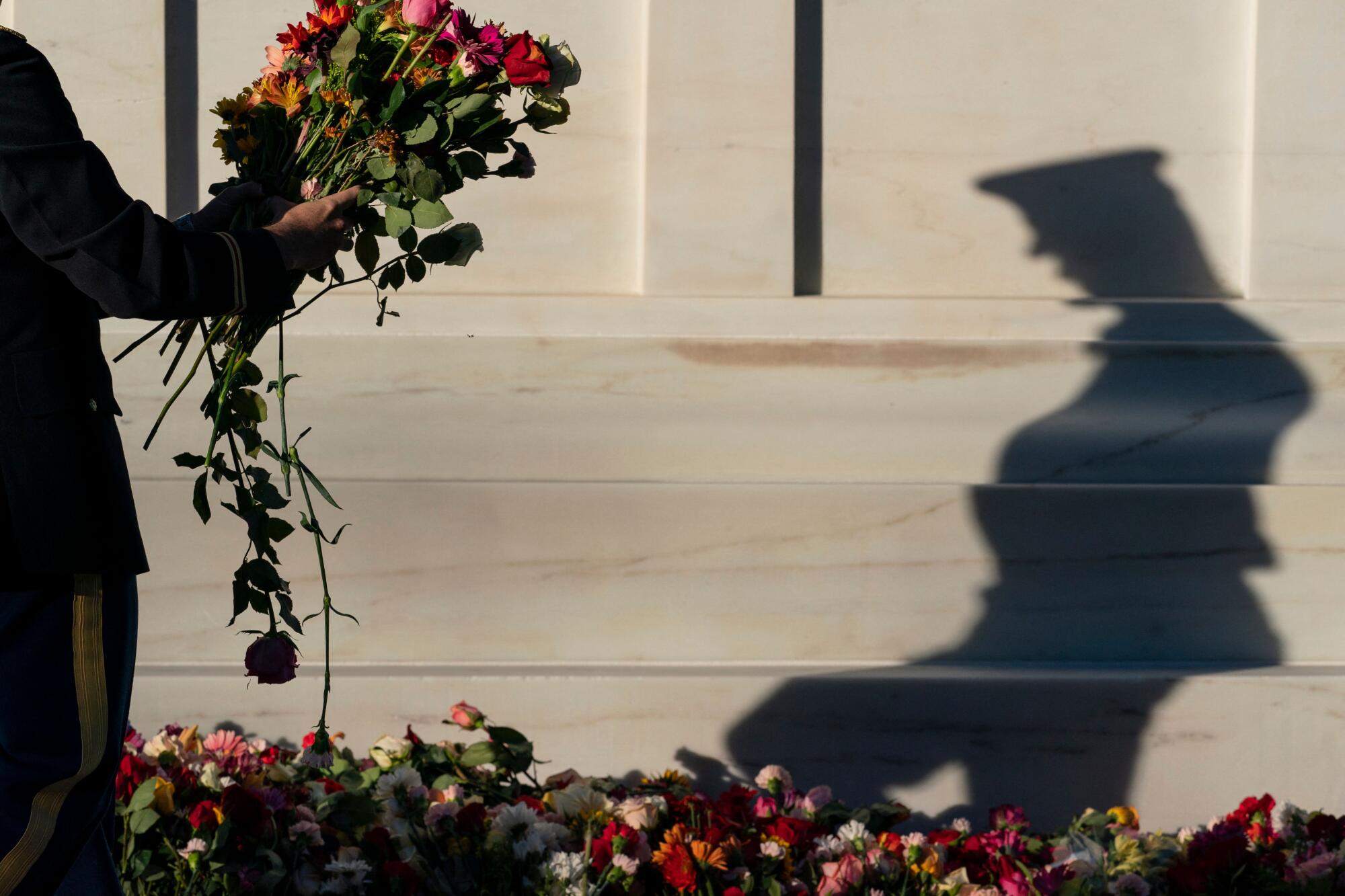A soldier with the 3rd U.S. Infantry Regiment, known as The Old Guard, moves flowers