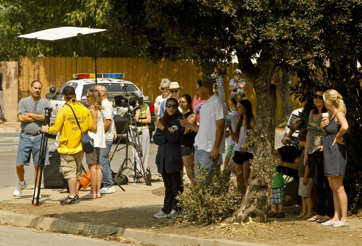 Neighborhood residents gather along Portrero Road in Newbury Park to watch as fire crews mop up after pushing the Springs fire away from the area.