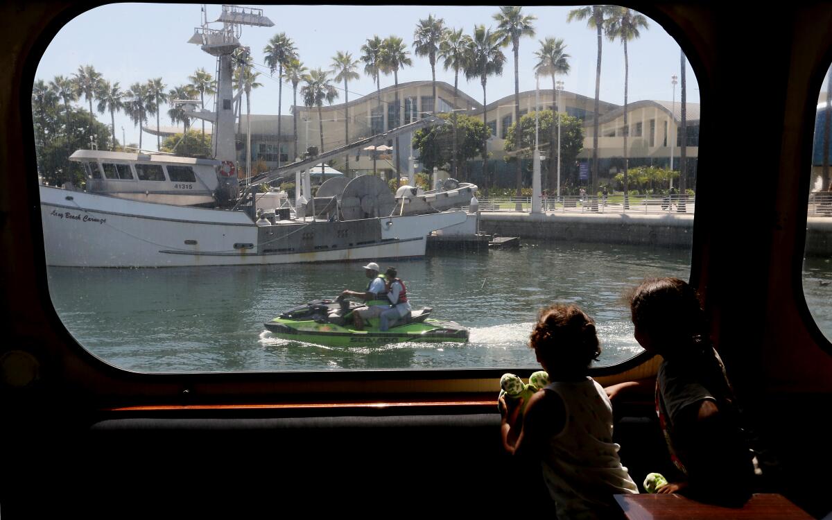 Children look out the window of a tour boat as it departs for a  harbor cruise in Long Beach.