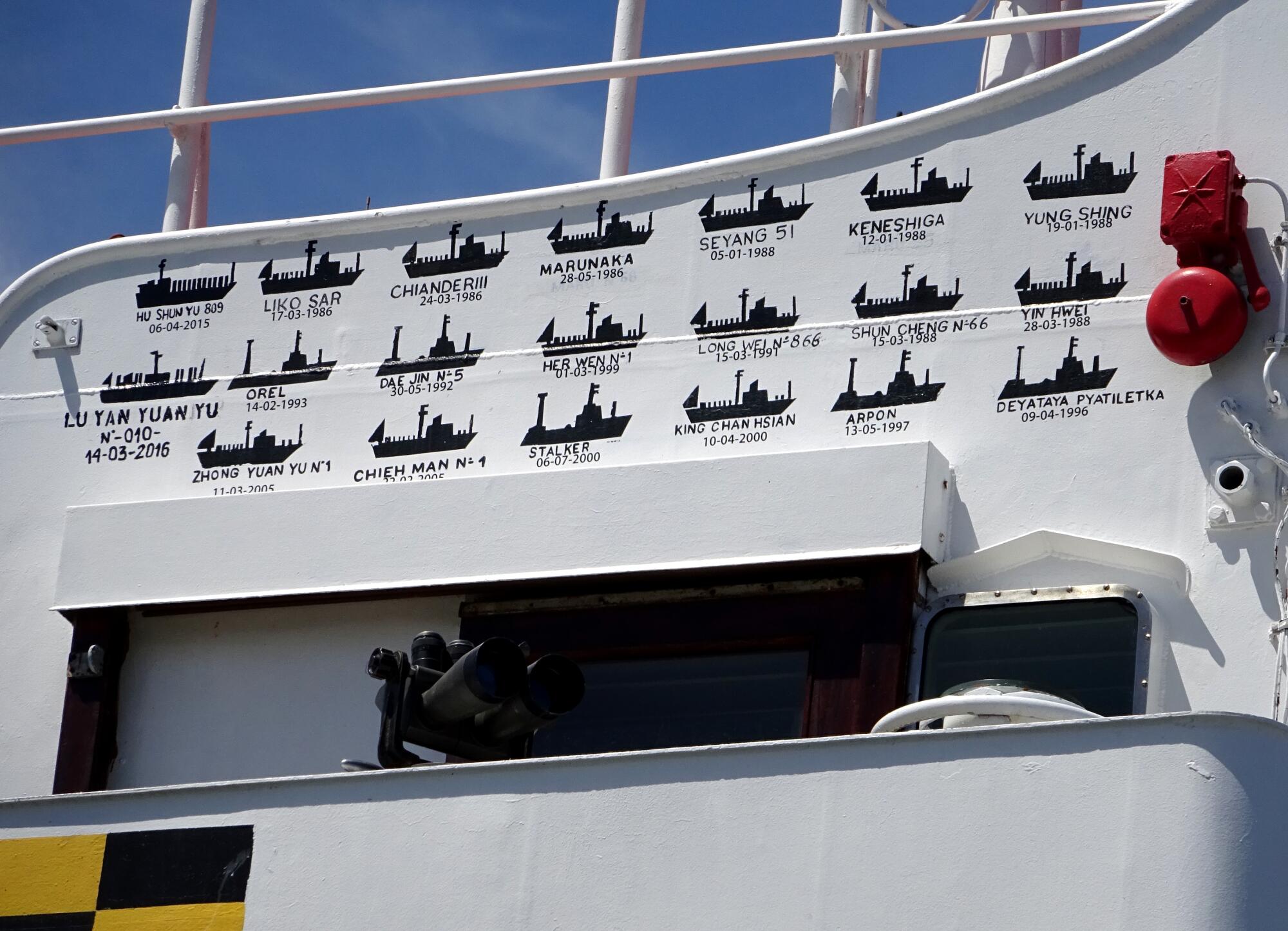 Three rows of black silhouettes of vessels adorn the white surface on the side of a ship