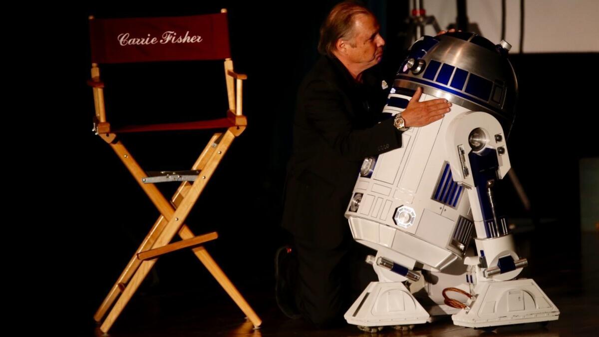 Todd Fisher hugs R2-D2 at a memorial for his sister, Carrie Fisher, and his mother, Debbie Reynolds, at Forest Lawn Memorial Park-Hollywood Hills in Los Angeles on Saturday. (Francine Orr / Los Angeles Times)