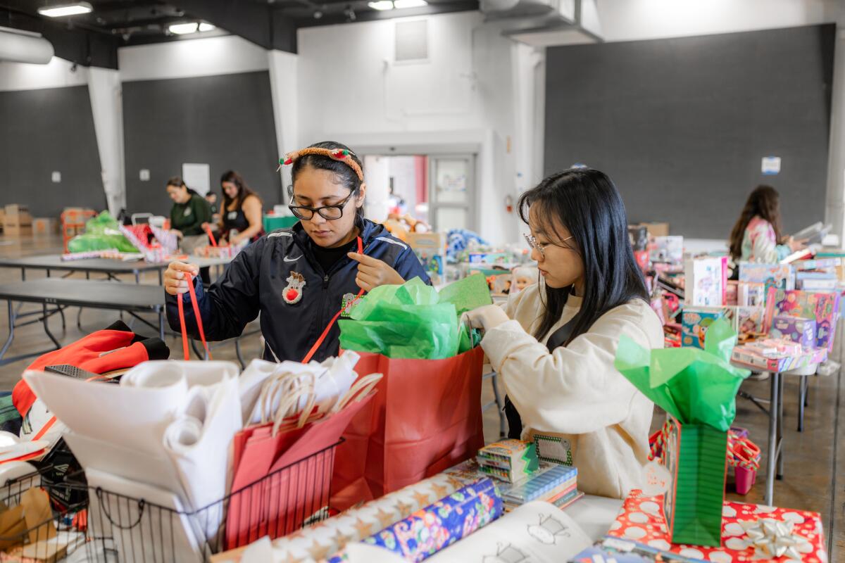 Volunteers help pack presents.