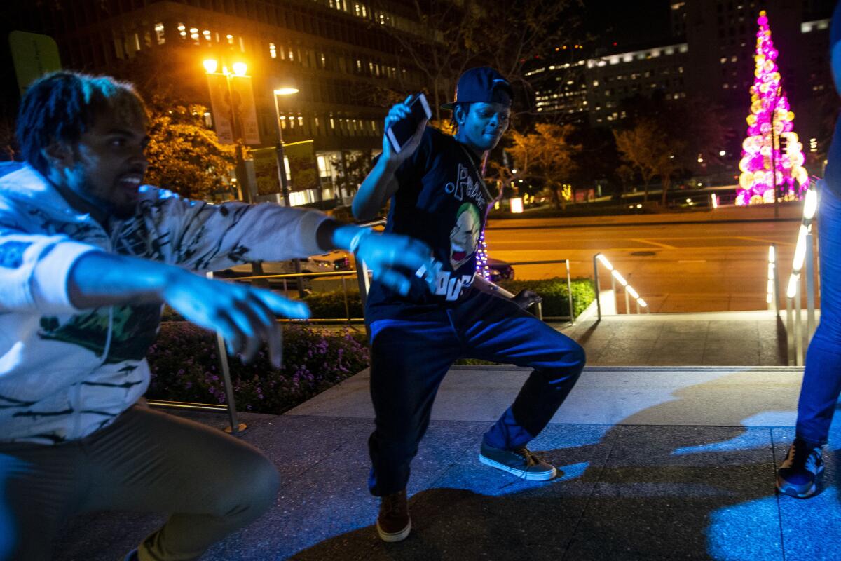 Dimitri Dunn, 19, center, of Koreatown, dances while on a break from filming a music video at Grand Park in Los Angeles.