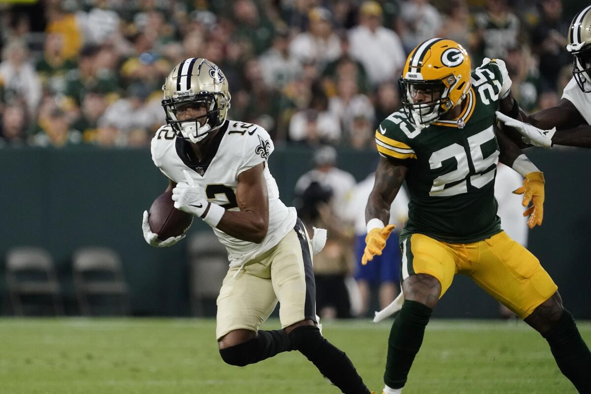 New Orleans Saints wide receiver Chris Olave (12) carries on a reception during the first half of a preseason NFL football game against the Green Bay Packers Friday, Aug. 19, 2022, in Green Bay, Wis. (AP Photo/Morry Gash)