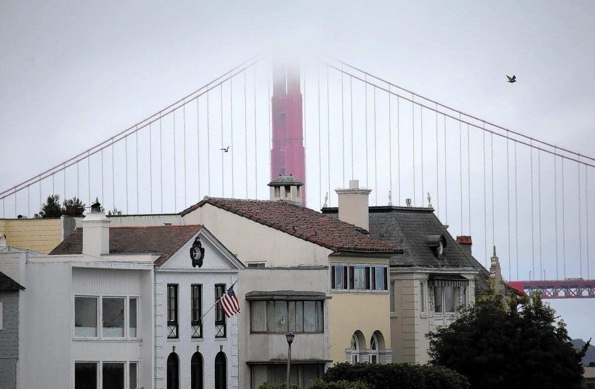 The Golden Gate Bridge stands behind a row of houses in San Francisco on July 17.