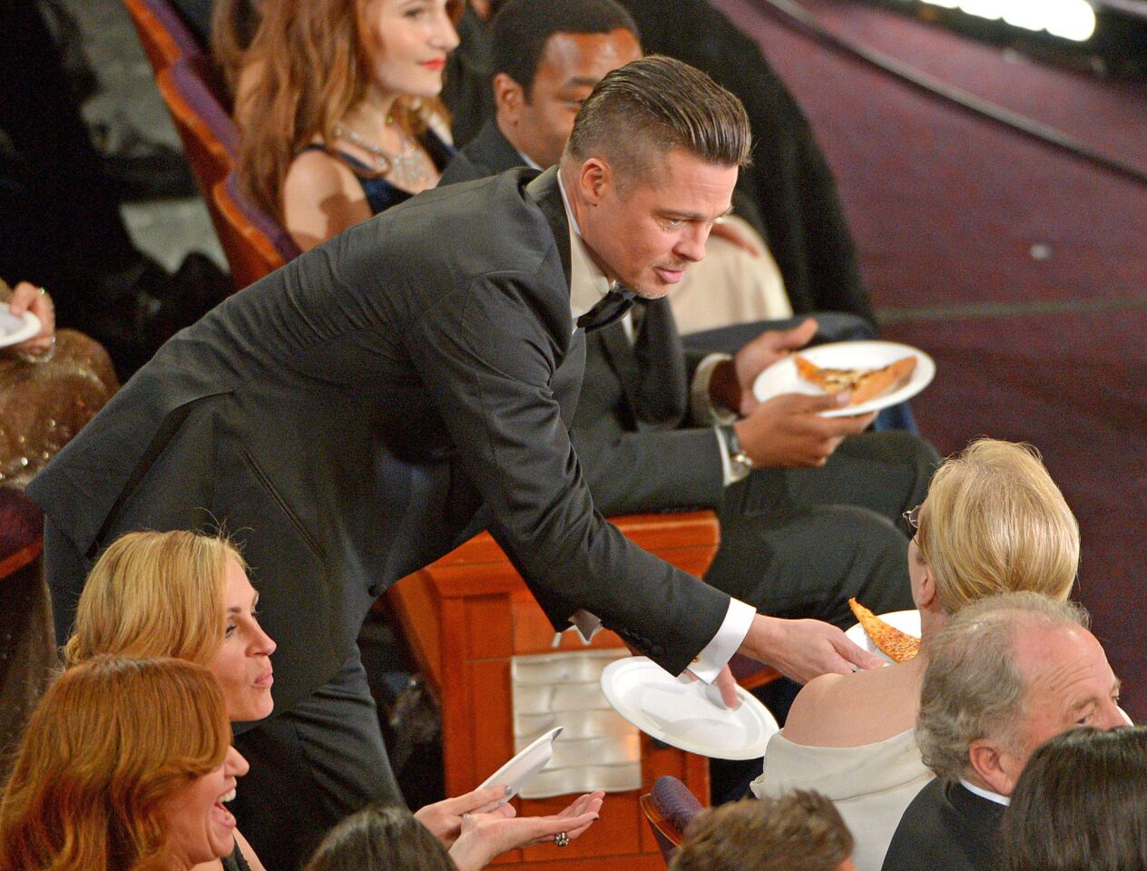 Brad Pitt offers Meryl Streep pizza.