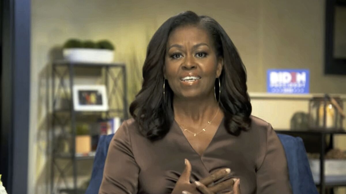 Michelle Obama gestures with her hands as she speaks