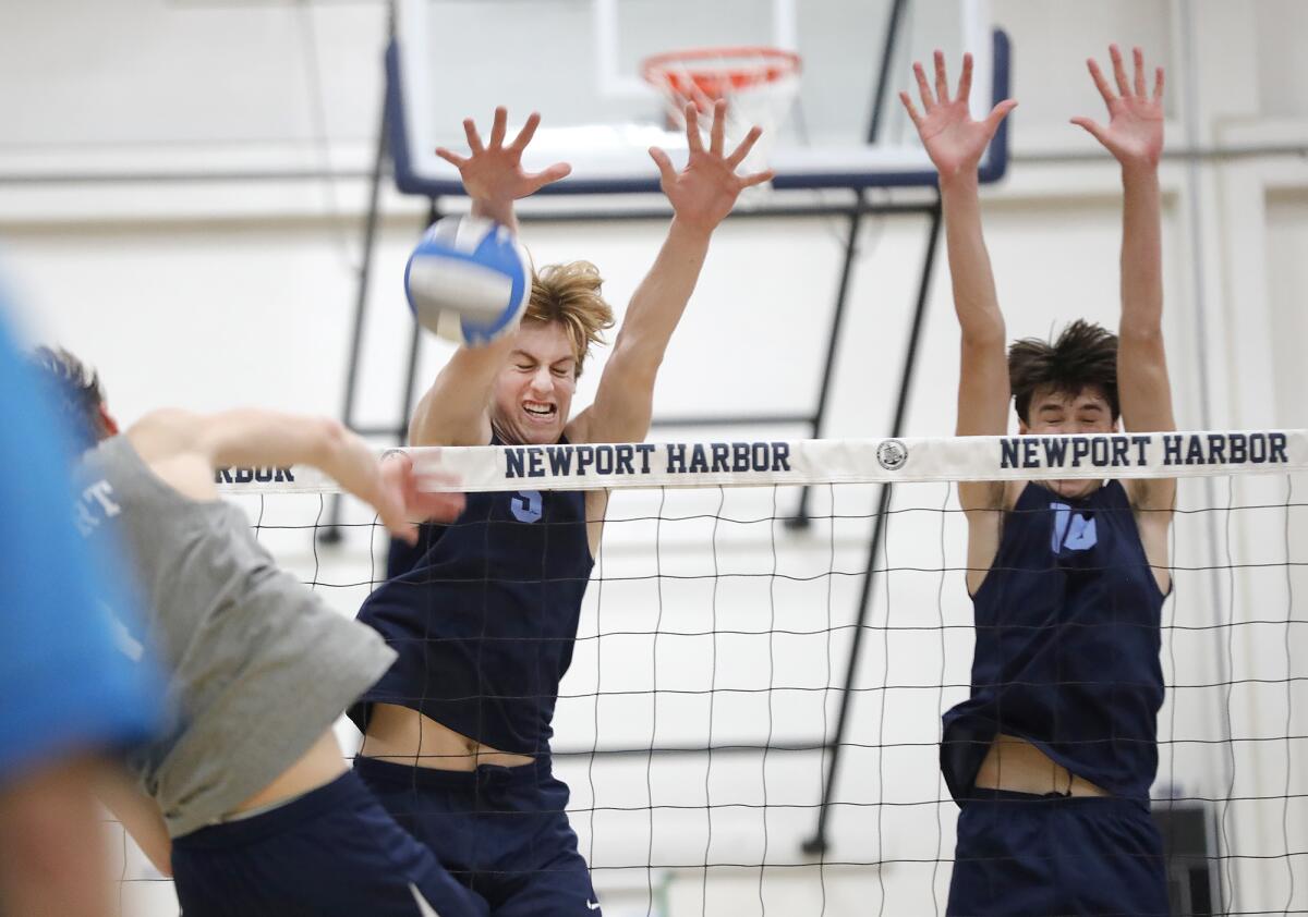 Corona del Mar's George Bruening (5) makes a block on Newport Harbor's Luca Curci (4), with help from Cade Alacano (10).