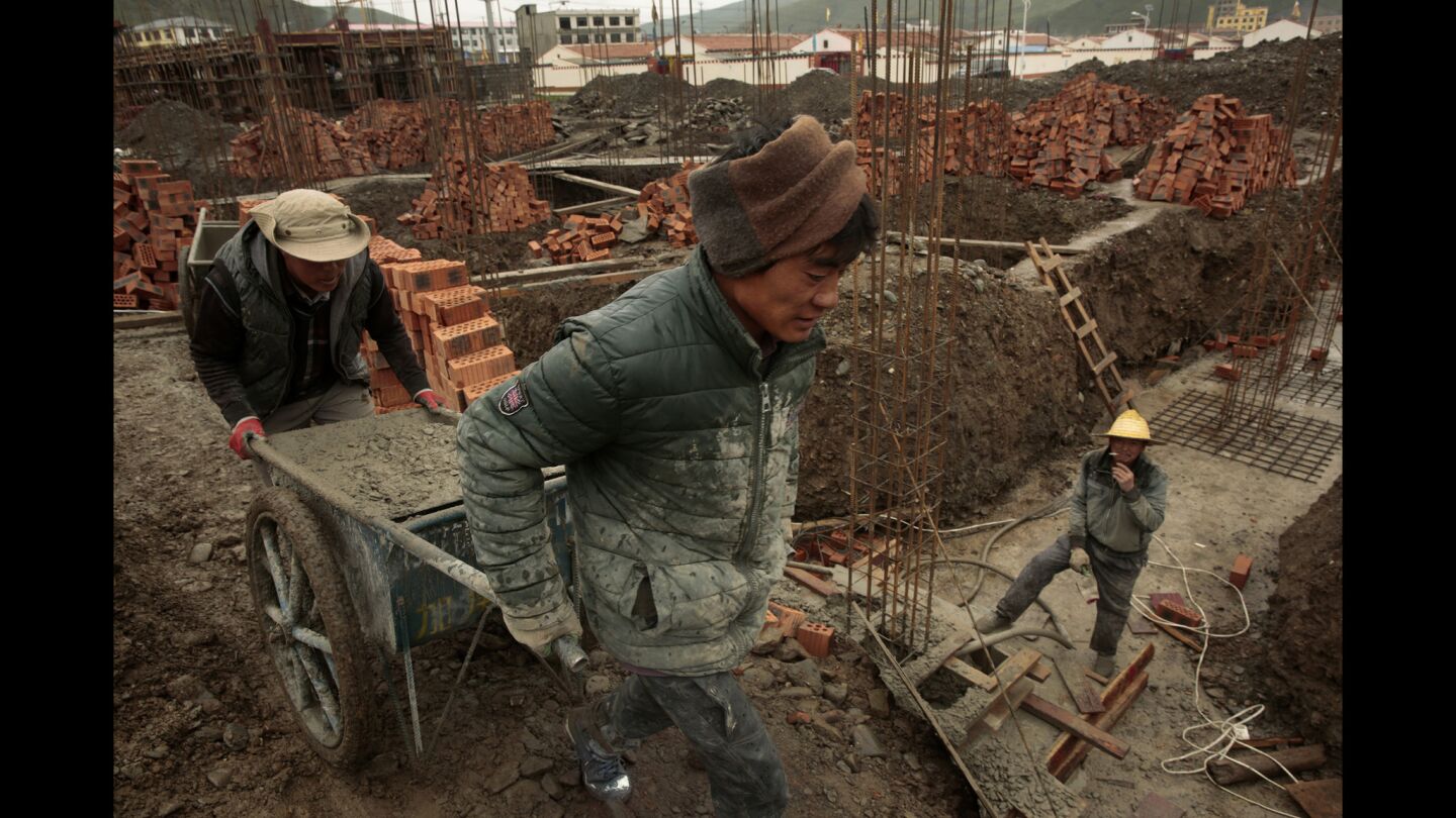 Liu Young, 41, toils as a construction worker on a home-building site in Jiuzhi City, China.