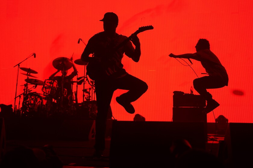 From left, Brad Wilk, Tom Morello and Zack de la Rocha of Rage Against The Machine perform at the United Center on Monday, July 11, 2022, in Chicago. (Photo by Rob Grabowski/Invision/AP)