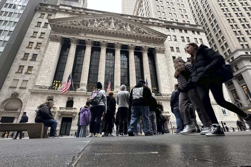 People walk past the New York Stock Exchange Wednesday, March 27, 2024. World shares are mixed after Wall Street slipped a bit further from its record highs. (AP Photo/Peter Morgan)