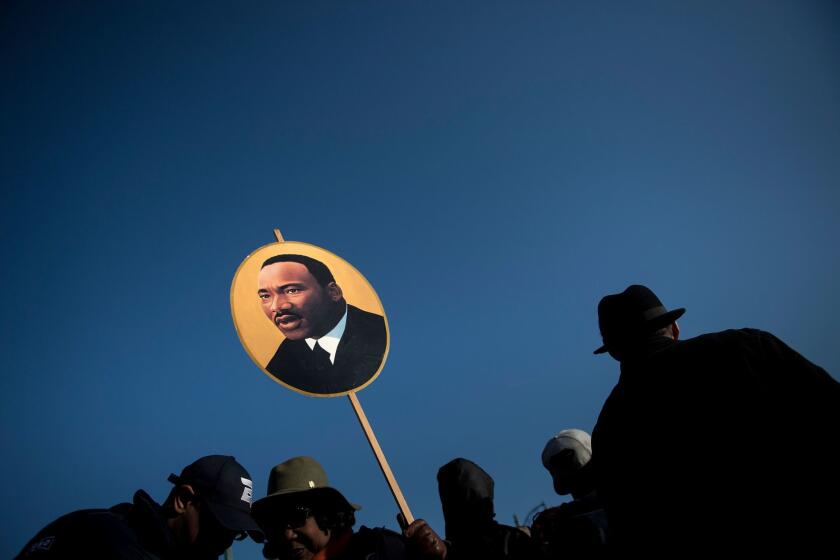 TOPSHOT - A woman holds a poster of Martin Luther King Jr. on the 50th anniversary of his assassination April 4, 2018 in Memphis, Tennessee. / AFP PHOTO / Brendan SmialowskiBRENDAN SMIALOWSKI/AFP/Getty Images ** OUTS - ELSENT, FPG, CM - OUTS * NM, PH, VA if sourced by CT, LA or MoD **