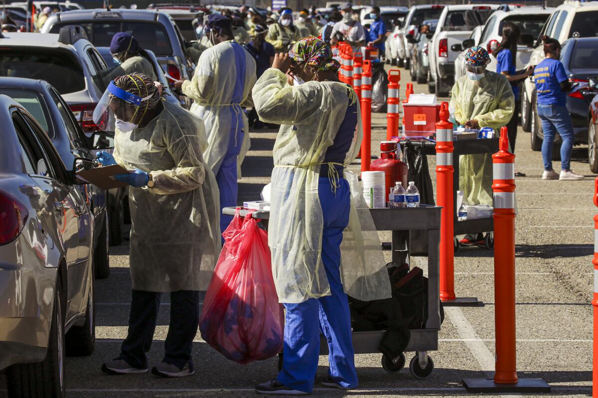 Healthcare workers assist at a drive-through vaccine super site.