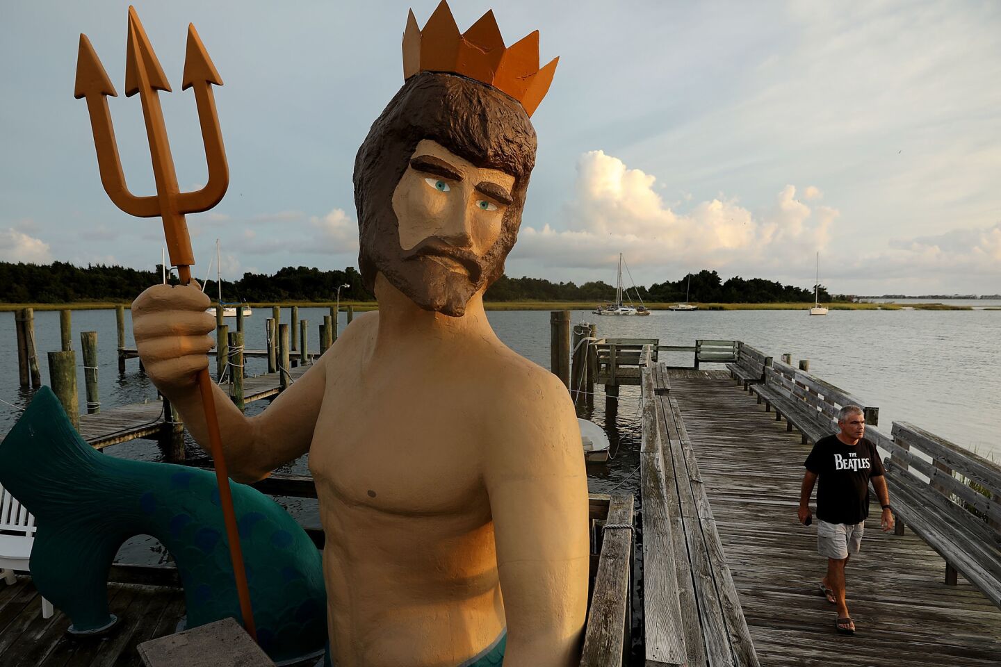 A statue of Poseidon stands along the boardwalk in Morehead City, N.C., on Wednesday. Many coastal areas in Virginia and the Carolinas are under evacuation orders.