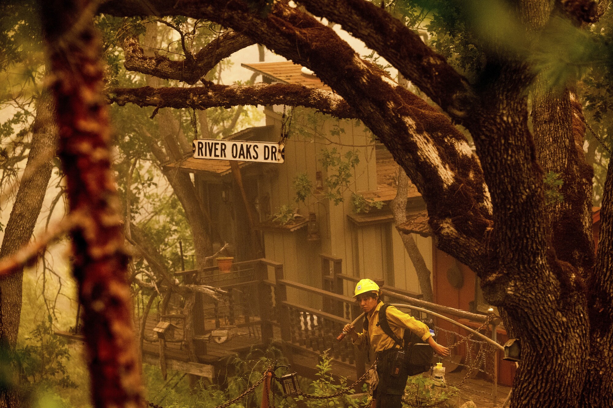 A firefighter battling the McKinney fire protects a cabin in Klamath National Forest.