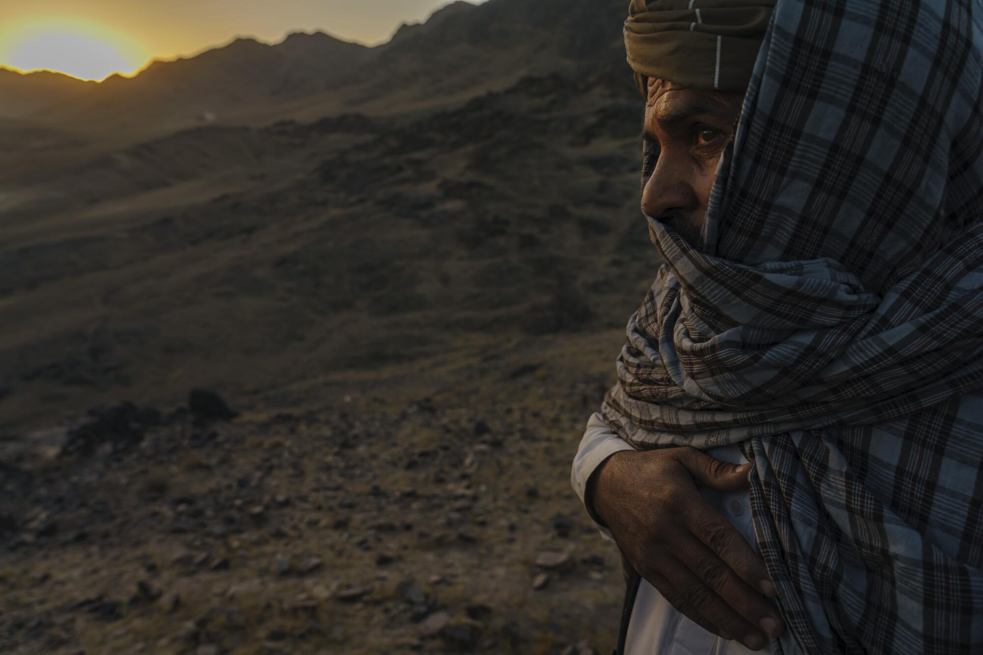 A Taliban commander looks over mountains.