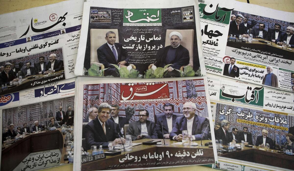 A picture shows Iranian newspapers with pictures depicting Iranian President Hassan Rouhani, U.S. President Obama, Iranian Foreign Minister Mohammad Javad Zarif and his American counterpart, John Kerry on a newsstand in Tehran on Saturday.