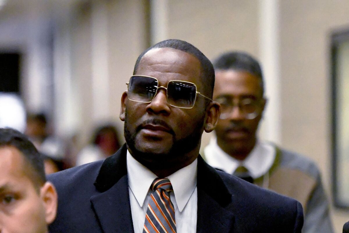 A middle-aged man in sunglasses wearing a suit.
