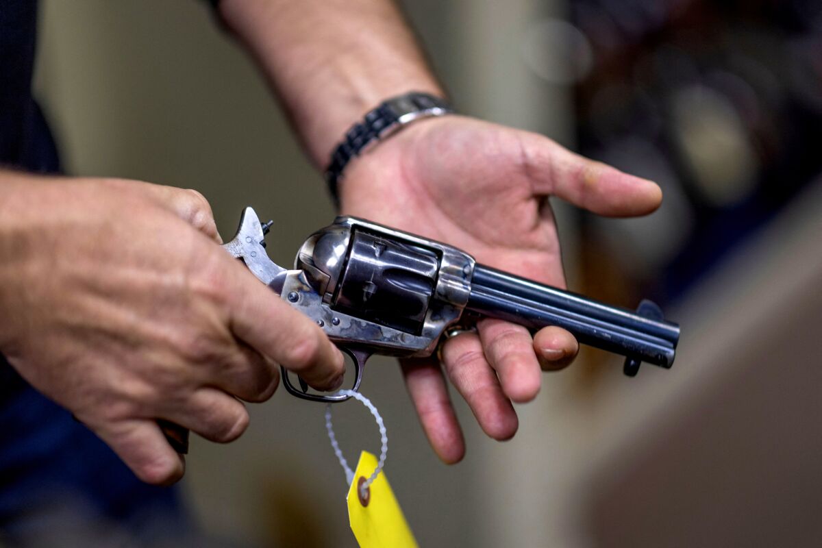 Props expert Guillaume Delouche at Independent Studio Services holds a prop gun 