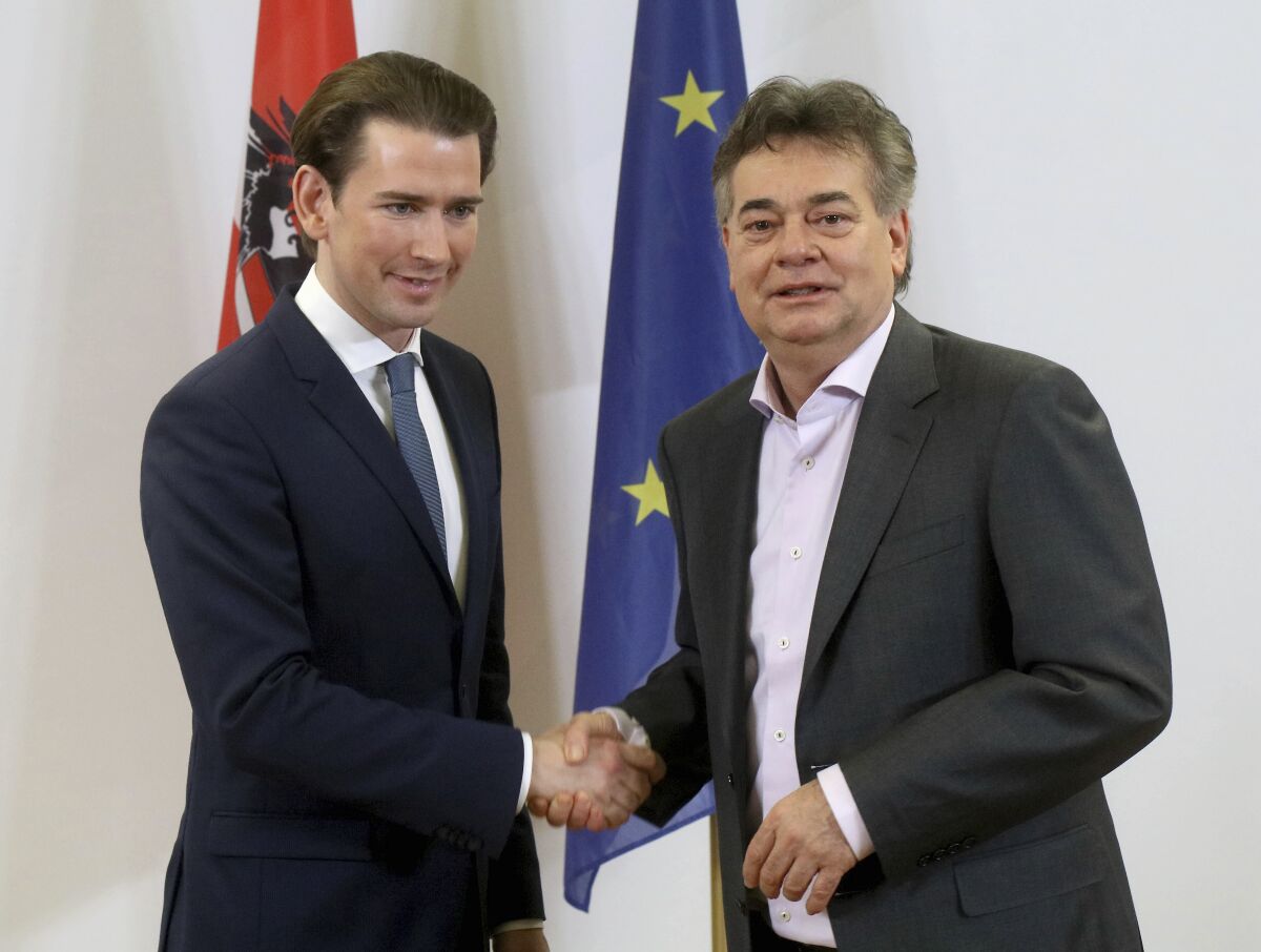 Sebastian Kurz, left, head of the Austrian People's Party, OEVP, shakes hands with Werner Kogler, right, head of the Austrian Greens during a press conference after finishing the coalition negotiations in Vienna, Austria, Wednesday, Jan. 1, 2020. (AP Photo/Ronald Zak)