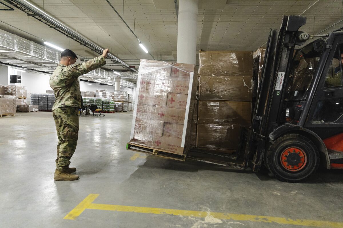 FILE - In this image provided by the U.S. Army, paratroopers assigned to the 82nd Airborne Division, assist with unloading humanitarian goods in support of the United States Agency for International Development (USAID) in preparation of potential evacuees from Ukraine at the G2A Arena in Jasionka, Poland, on Feb. 25, 2022. (Sgt. Robert Whitlow/U.S. Army via AP, File)
