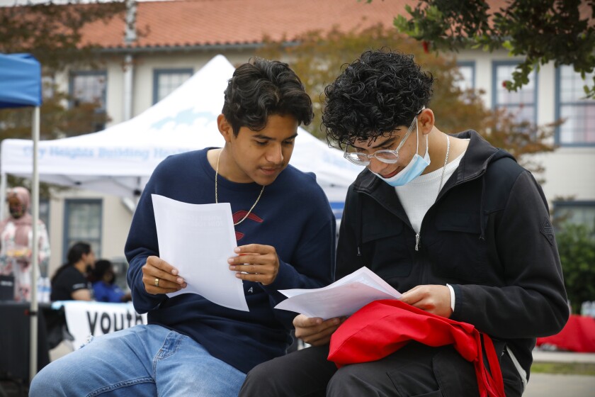 Juan Chinchilla, 16, and Bryan Morales, 17, look over handout materials