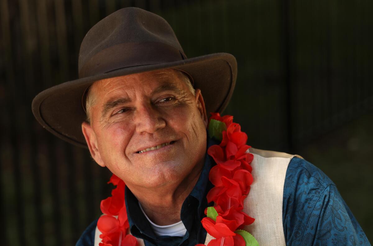 The Rev. Andy Bales wearing a brimmed hat and floral garland