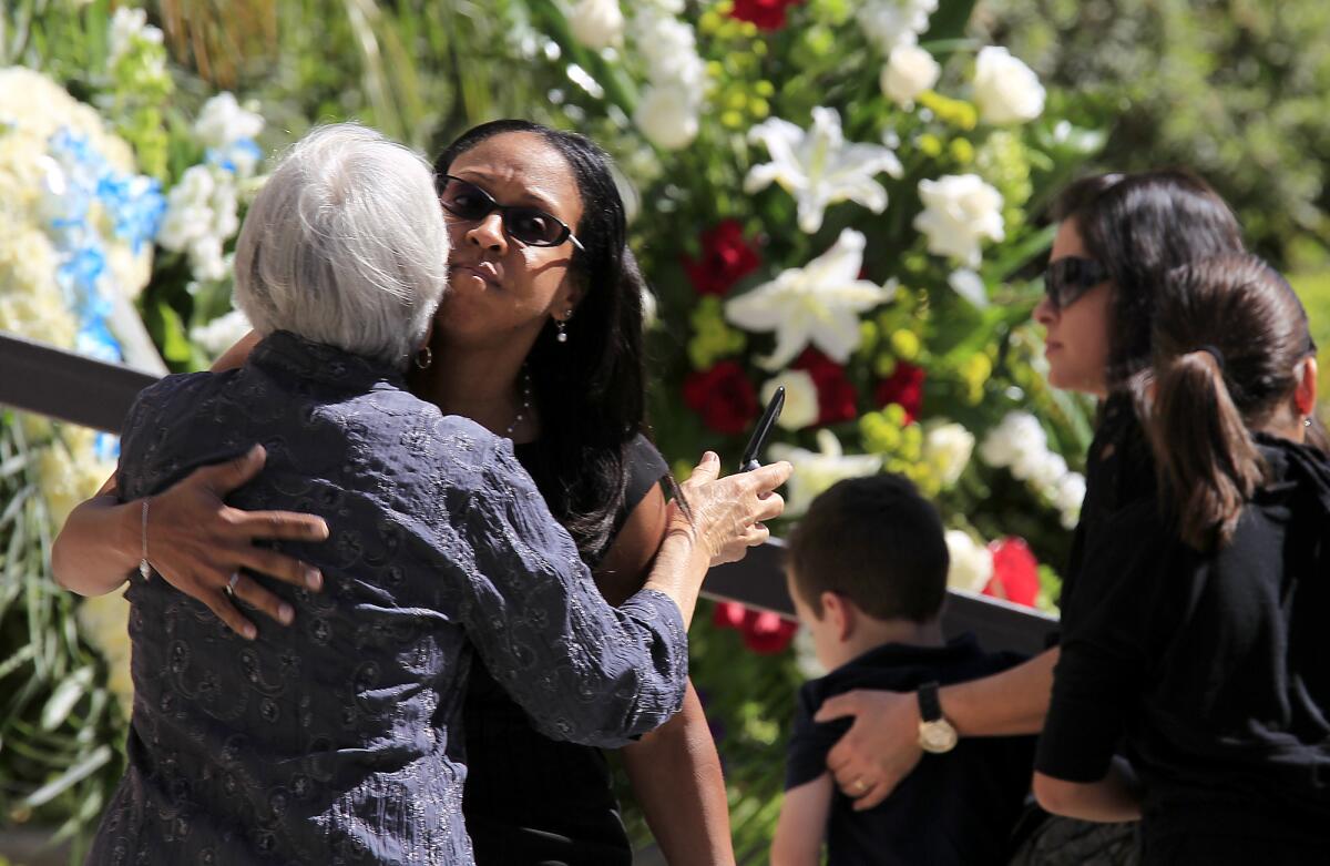 Mourners embrace as a funeral Mass gets underway for Marcela and Carlos Franco at St. Monica Catholic Church. The father and daughter were killed in the Santa Monica College shooting earlier this month.