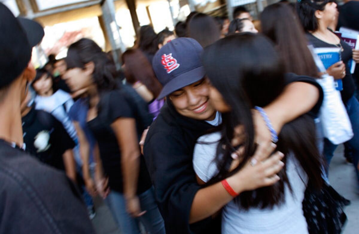 Karla Valencia, 17, is embraced by a friend outside Santee High School, where she was recently reaccepted after completing studies at SEA Manchester Charter School in South Los Angeles.