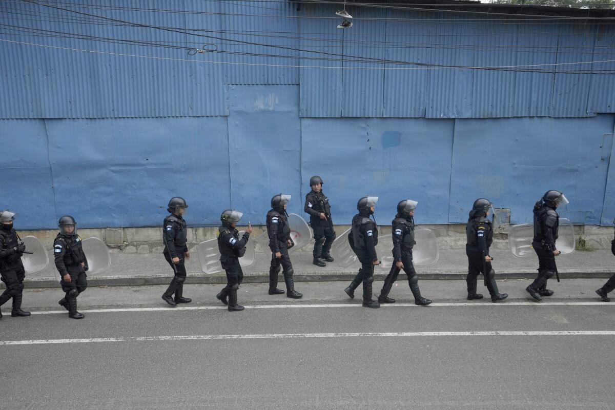 Policías antimotines marchan por una carretera bloqueada por manifestantes en Ciudad de Guatemala 