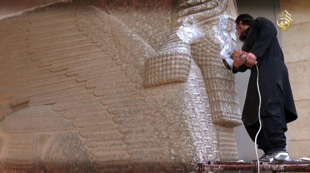 A still from a video shows an Islamic State militant destroying the statue of Lamassu, an Assyrian diety, in the northern Iraqi Governorate of Nineveh last year.