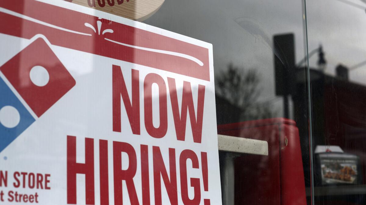 A hiring sign is posted at a Domino's Pizza outlet in Jersey City, N.J., on April 14.