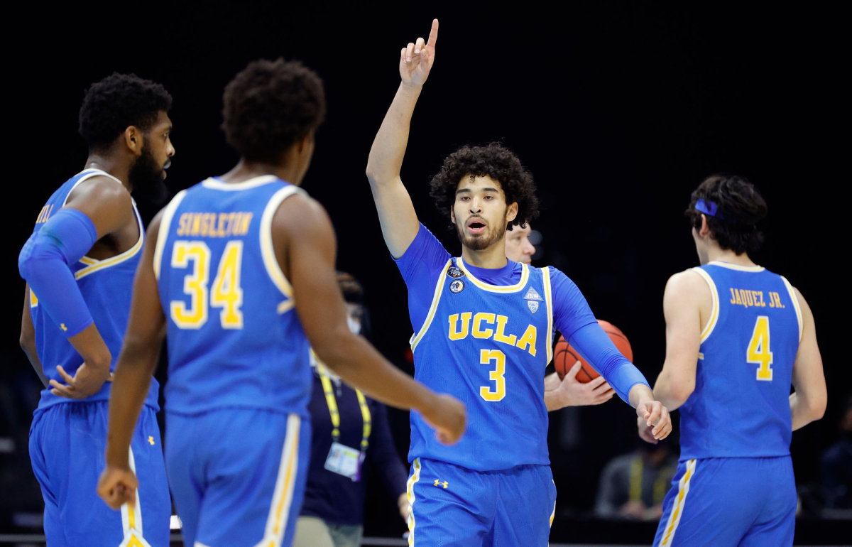 UCLA's Johnny Juzang points up while walking toward teammates