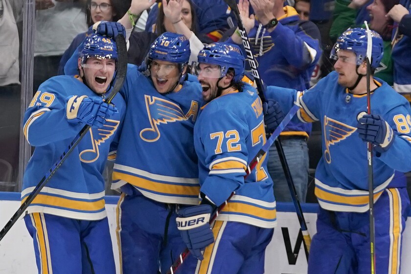 St. Louis Blues' Brayden Schenn is congratulated by teammates Ivan Barbashev, left, Justin Faulk (72) and Pavel Buchnevich (89) after scoring the game-winning goal in overtime of an NHL hockey game against the Minnesota Wild Saturday, April 16, 2022, in St. Louis. (AP Photo/Jeff Roberson)