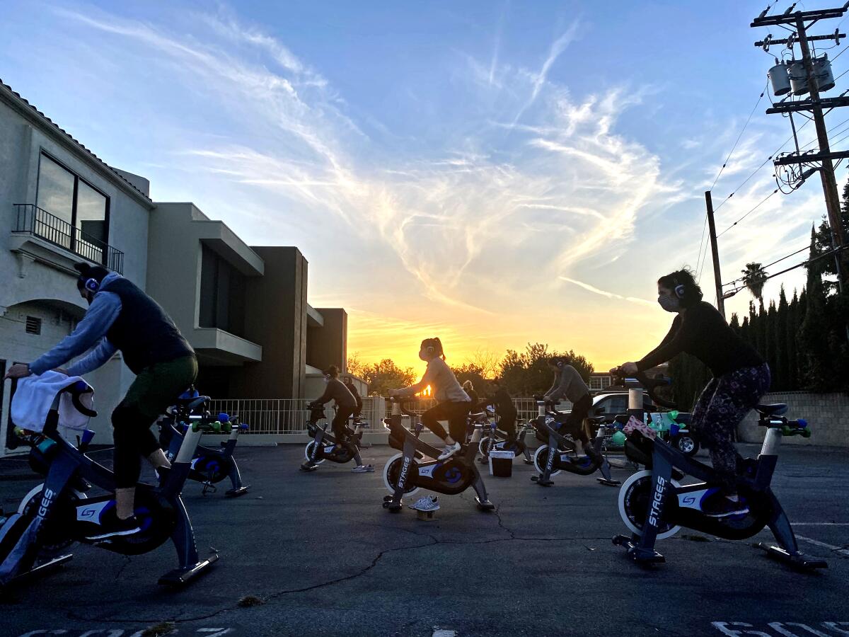 Cyclists are on stationary bikes outside.