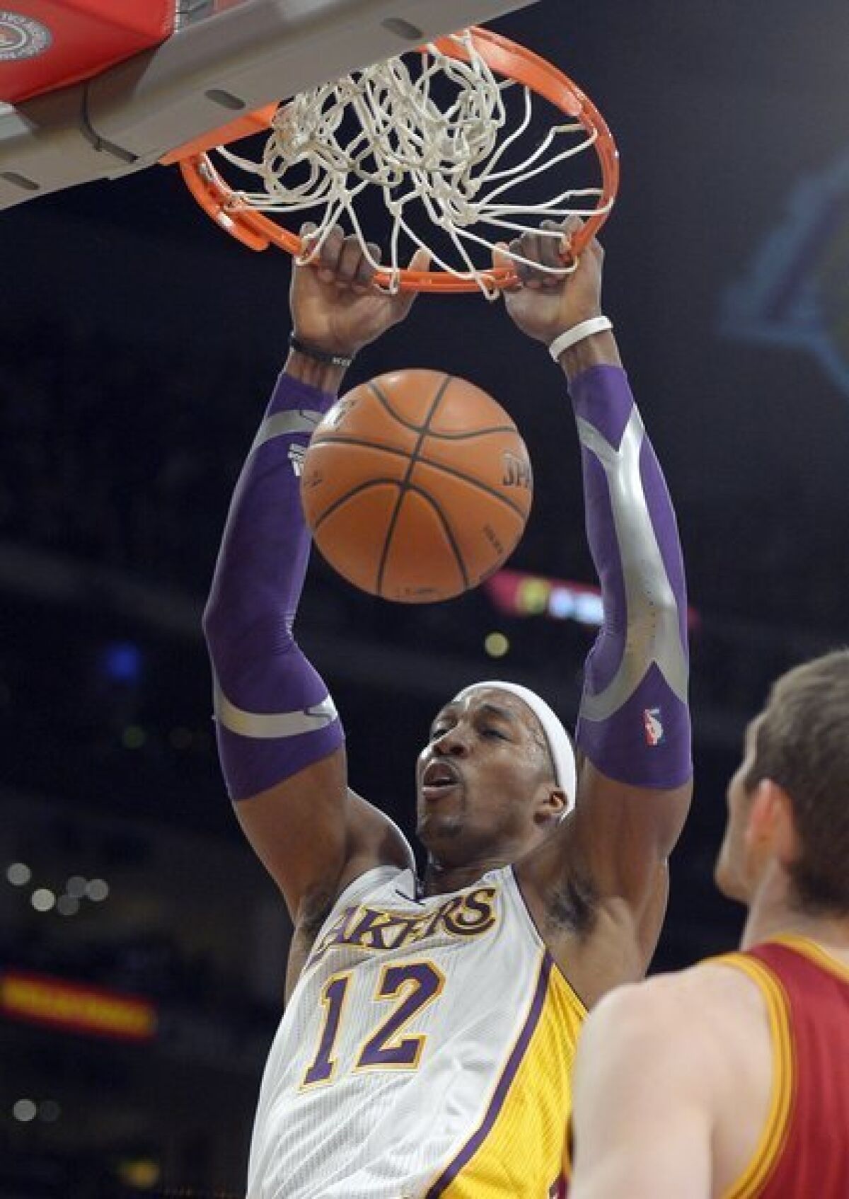 Lakers center Dwight Howard dunks as Cleveland Cavaliers center Tyler Zeller watches.