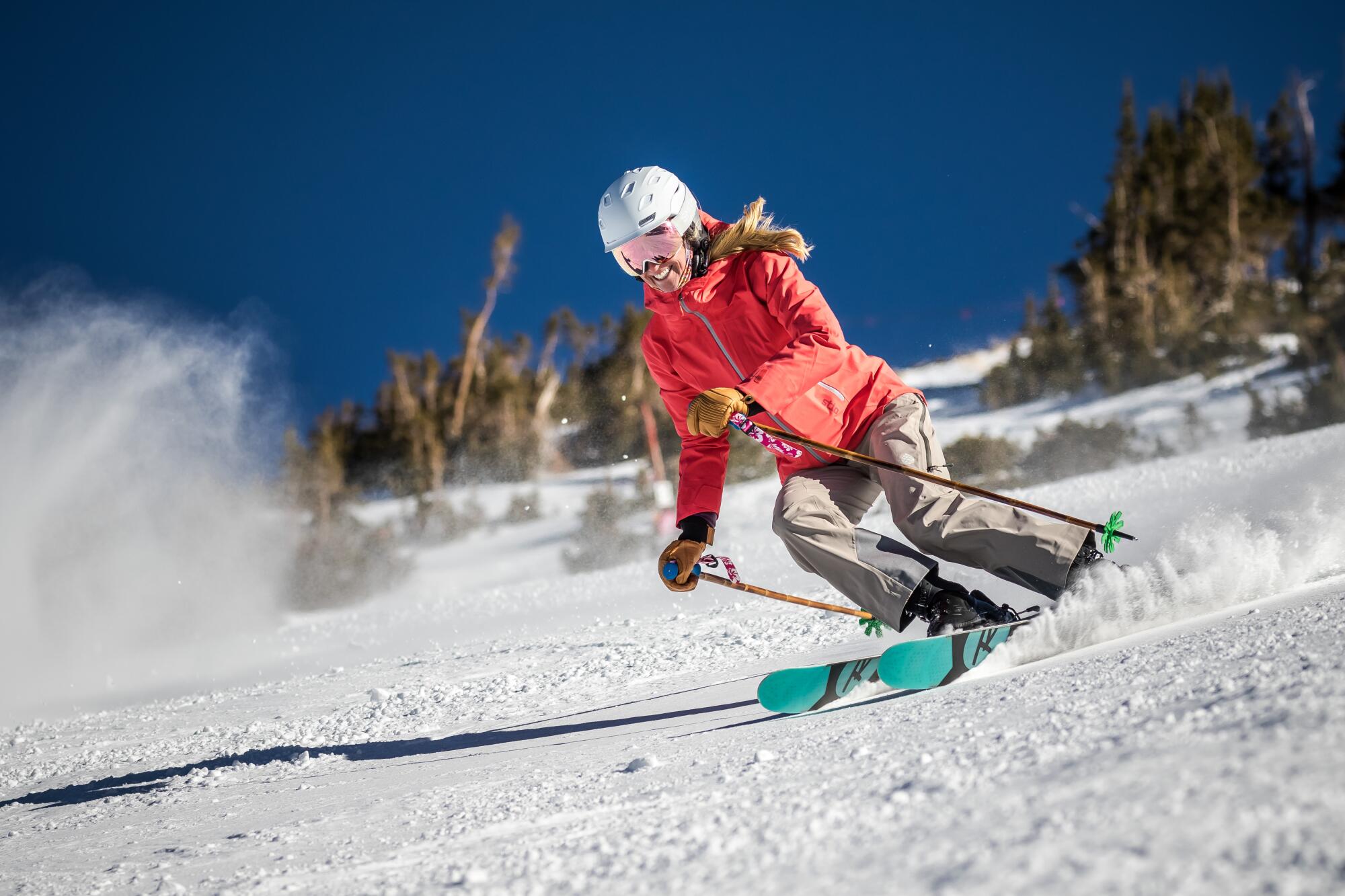 A woman skis down a mountain smiling