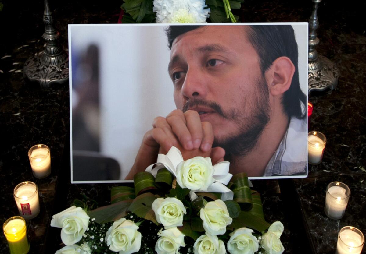 Una foto del asesinado fotoperiodista mexicano Rubén Espinosa fue colocada entre flores y velas en su ataud en una funeraria en ciudad de México, el lunes 3 de agosto de 2015. Grupos de protección a periodistas en México han manifestado sus temores de que las autoridades no consideren que el crimen de Espinosa podría estar relacionada con su trabajo, a pesar de que el propio fotoperiodista y varios de sus colegas habían dicho que dejó el estado de Veracruz donde trabajaba por temores a su seguridad.