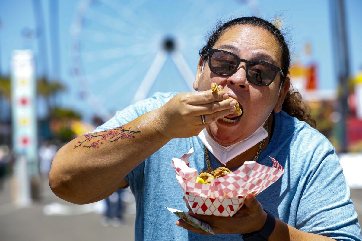 Christina Negron, of Imperial Beach dives into an order of fried frog legs at HomeGrownFun 