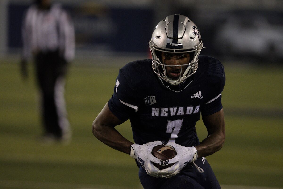 A football player grasps the ball both hands