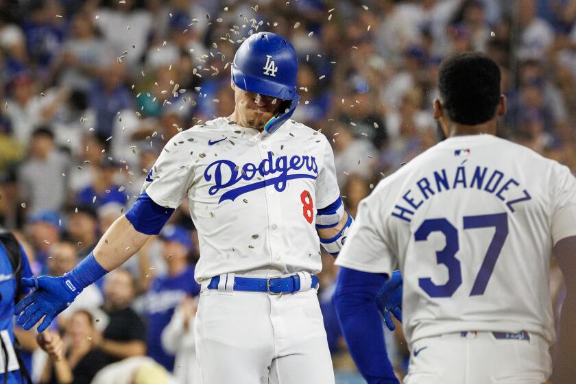 LOS ANGELES, CA - AUGUST 9, 2024: Los Angeles Dodgers third base Enrique Hernandez (8) gets hit with a sunflower seed shower form Los Angeles Dodgers outfielder Teoscar Hernandez (37) after hitting a two-run homer against the Pittsburgh Pirates in the fifth inning at Dodgers Stadium on August 9, 2024 in Los Angeles, California. (Gina Ferazzi / Los Angeles Times)