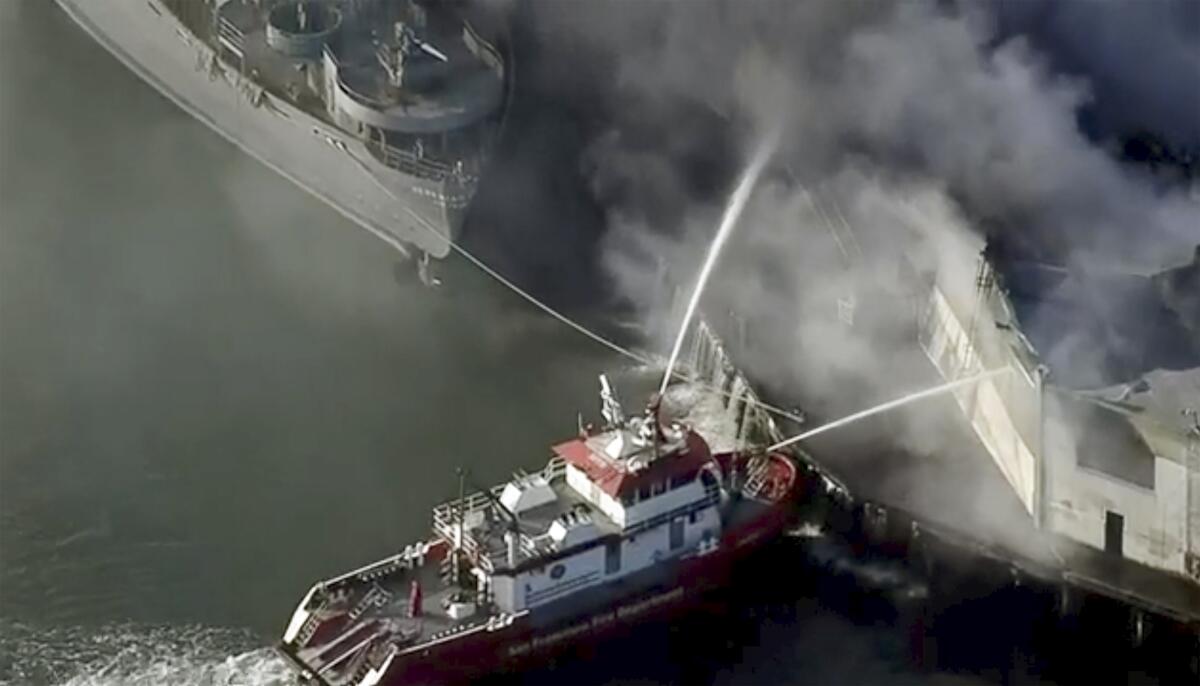 A fireboat continues to pour water on Fisherman's Wharf in San Francisco on Saturday morning after a massive fire erupted overnight at a warehouse.