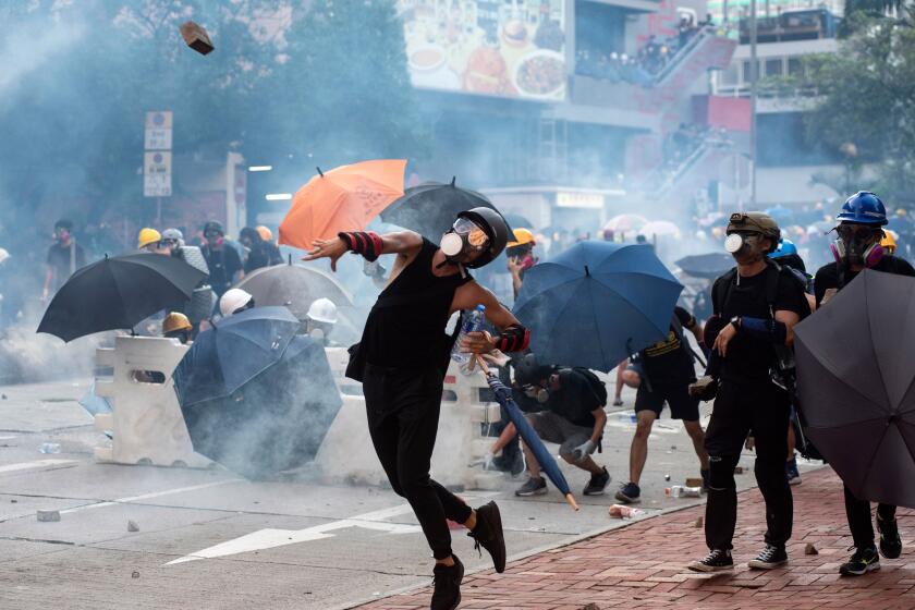 Mandatory Credit: Photo by MIGUEL CANDELA/EPA-EFE/REX (10354508w) Anti-extradition protesters throw bricks as others react after police fired tear gas at them during clashes in Wong Tai Shin area in Hong Kong, China, 05 August 2019. Hong Kong is in the midst of a citywide strike following a ninth consecutive weekend of multiple anti-extradition rallies and intense clashes between demonstrators and police over the now suspended extradition bill to China. Anti-extradition protesters clash with police in Hong Kong, China - 05 Aug 2019 ** Usable by LA, CT and MoD ONLY **