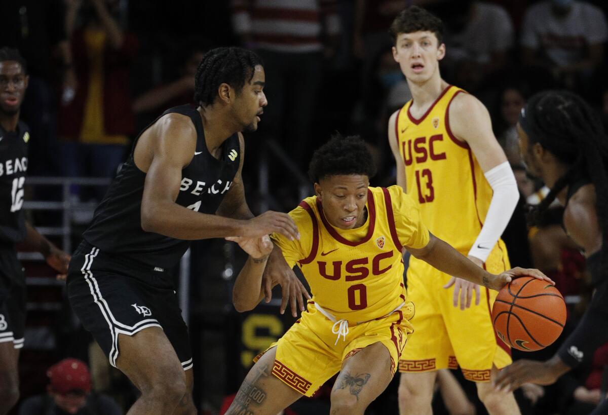 USC guard Boogie Ellis (0) grabs a rebound in front of Long Beach State forward Jordan Roberts during Sunday's game.