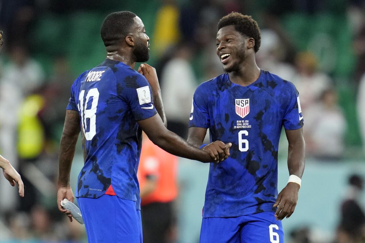 Americans Shaq Moore (18) and Yunus Musah celebrate after defeating Iran in a World Cup Group B game.